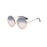 Side view of grey and pink, large circle sunglasses, with tinted lenses and bee detail on the lenses.