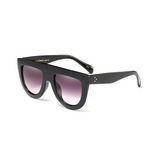 Side view of black, flat top oversized sunglasses, with black gradient lenses.