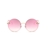 Front view of pink, large circle sunglasses, with mirror lenses and bee detail on the lenses.